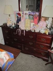 More dolls, sitting atop a Queen Anne style cherry bureau