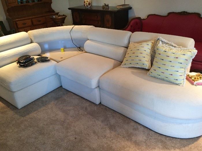 modern white couch with sections and panel that lights up; toggle switch helps moves the light from bright to moody