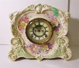 Clock # 10 C/1900 Ansonia China case mantle clock, open escapement, winged lions, Royal Bonn case, 12" h.