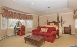 King size four poster bed, rose velvet loveseat, leather ottoman, wicker dressing table