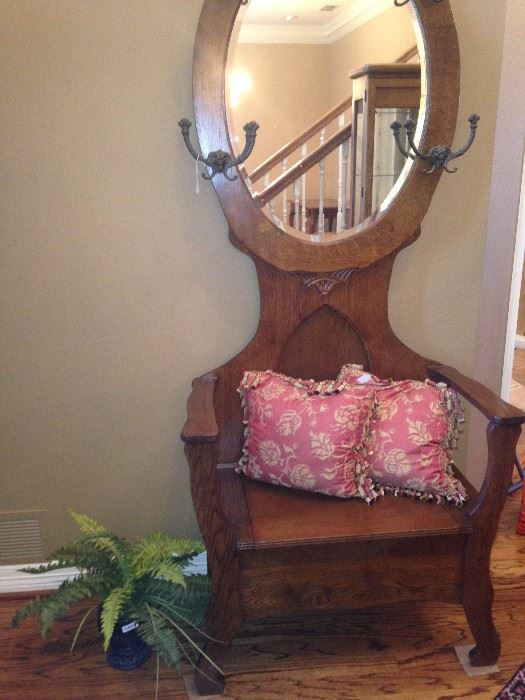 Antique hall tree with seat storage and oval mirror