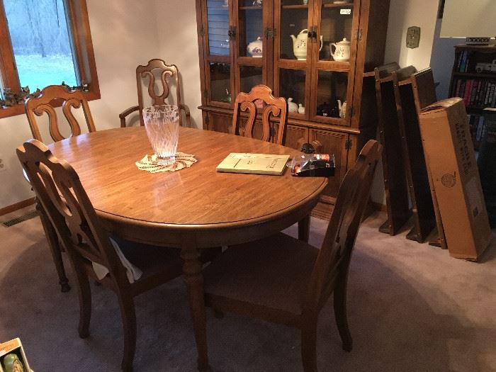 Beautiful oak finish on this dining room table with six chairs (one captain's chair) and three leaves with pads -- matching china cabinet.