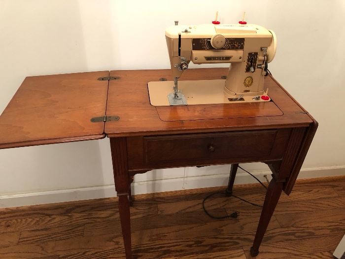 Vintage Singer sewing machine in wood cabinet