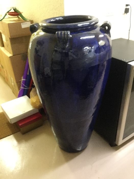 To beautify an outdoor setting; Large cobalt blue outdoor pottery, rounded lip at opening and 4 matching decorative handles, 3’ 10” tall