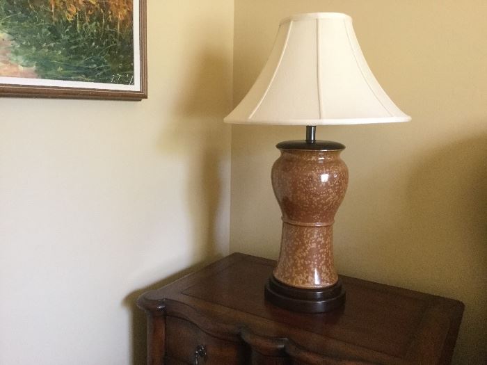 Carmel ceramic lamp with round top on flared bottom with a round wooden base, molted taupe and brown finish