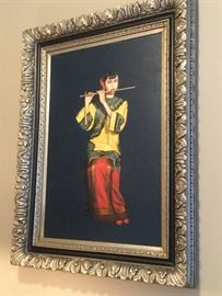 One of many paintings available for sale: “The Flutist” original oil painting by Iki, woman wearing decorative yellow tunic and red skirt, black background, acanthus leaves design on framing, with black accent to highlight painting, 3” 10’ H x 2’ 10” W 
