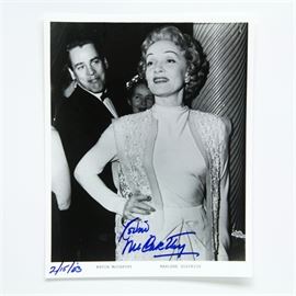 Kevin McCarthy Signed Photo with Marlene Dietrich: A signed photo of actor Kevin McCarthy. This black-and-white photograph taken at a black-tie event depicts actress Marlene Dietrich, with actor Kevin McCarthy standing just behind her and looking at her from over her shoulder. The printed caption reads “Kevin McCarthy” and “Marlene Dietrich”, and the photo is signed “Kevin McCarthy” and dated “2/15/03” in blue marker.