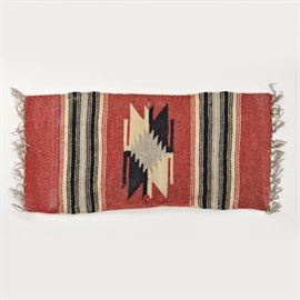 Vintage Native American Style Handwoven Woolen Textile: A vintage Native American style handwoven wool textile. The textile has a center field in red with a cream, gray and black arrowhead design, with cream, black and gray banding to each side and ecru hand-tied fringe to each end.