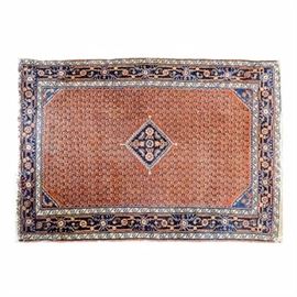 Semi-Antique Hand-Knotted Persian Mir Wool Accent Rug: A semi-antique hand-knotted Persian Mir wool accent rug. The rug has a tomato red central background populated with an overall boteh pattern in navy blue, yellow gold and off white, with a diamond-shaped gul medallion in navy blue with coral red, yellow gold, off white and black floral motifs to the center. The rug has a complex compound border with a major Samovar border in navy blue and guard stripes in cream in the running dog border. The rug has off white warp fringe to both ends.