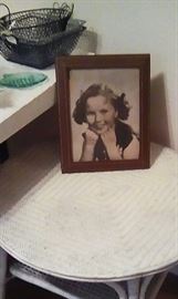 Shirley Temple framed photo on wicker table