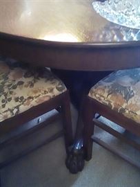 Round oak table and chairs.  Note claw feet