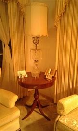 Beautiful vintage crystal lamp sitting on 4-legged front single-draw mahogany Duncan-Phyfe lamp table.
