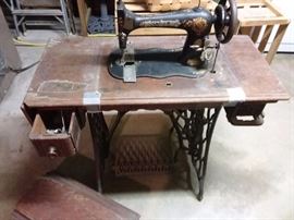 Antique sewing machine with treadle base