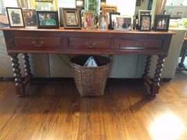 Contemporary barley-twistish mahogany sofa table, with three drawers.                                                                     Family photos of ugly babies, Children of the Corn, and hateful exes not included in sale. 