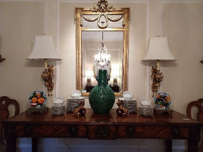 GORGEOUS Althorp by Theodore Alexander console serving table, "Dinner is Served", of flame figured mahogany veneer. The rectangular reeded edge crossbanded top above a breakfront frieze mounted with lion mask drop handles and a central Spencer crest, the bound cluster column tapering legs headed by brass stellar paterae and terminating in brass lion’s paw feet. The original Regency, circa 1820. The Ante Room.
W 84" x D 28" x H 37". This item was introduced Oct. 2004, retired Jan. 2016. Althorp has been home to the Spencer family for nearly 500 years. Huge green porcelain Asian vase, pair of wall-hung gold lamps, with shades & finials, vintage Asian porcelain foo dogs, partial set of the Herend "Coronation" china.