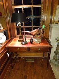 Vintage French leather-topped desk, with vintage Itlian tole lamp, French metal religious icon, one of a pair of 5-light brass and marble candleholders. Don't miss the purdy pheasant - if you shake some salt on his tail, he can be yours. Salt = cash, in this instance...