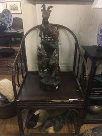 One of a pair of Chinese bamboo armchairs, circa 1900 with two decoys resting below.