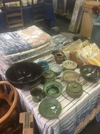 A further view of a table of North Carolina pottery and imported textiles.