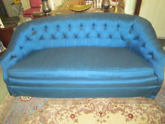 One of a pair of blue sofas with tufted backs