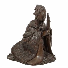 Japanese Bronze Kneeling Geisha Playing Reeded Instrument: A Japanese bronze depicting a kneeling Geisha playing a reeded instrument similar to a Sho. The figure’s draped garments are richly done in an allover floral relief, beautifully folded and overlapped at the back. The female figure wears upswept hair and a serene expression. The edge at the back of the robes appears to be numbered 66916.