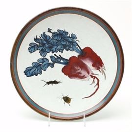 Antique Chinese Cloisonné Charger with Artisan Design: An antique Chinese cloisonné footed charger, c. 1900. The face of the charger displays a unique design of radishes and beetles with precise wire inlay highlighting the work of a skilled artisan. The distinct motif may indicate having been made for the Japanese market. Archaic scroll work borders the top of the plate. To the underside is a simple pattern and deep blue to the center.