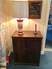 Early american red lamp.  Oak cabinet.