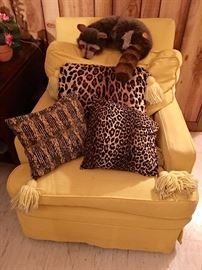 Upholstered chair, pillows and Steiff racoon.