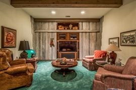 Basement den features vintage sound equipment, western art, antiqued leather chair...