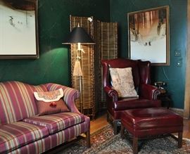 Ox blood leather Ethan Allen wing chair with ottoman (removed from sale by client), large original Michael Atkinson paintings, rattan screen and Chapman solid brass floor lamp