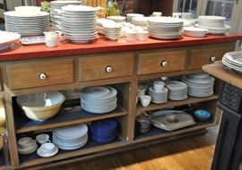 Many sets of white dinnerware in various sizes, fish shaped plates, rimmed soup bowls, etc. etc.