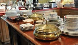 Kitchen island features brass casserole servers with pyrex inserts, more Gien dinner ware, espresso cups, small snack plates and Asian theme blue and white.
