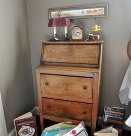 A pretty cute primitive small secretary with a Howard Miller desk clock, accent lamp and an adorable airplane music box