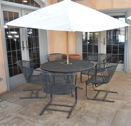 There are 3 Woodard wrought iron round table and chair sets.  This one features 5 chairs and comes with the umbrella, seat cushions and cover for the set during the winter months.  THIS SET SOLD AT THE PREVIEW, PLUS 1 OTHER SET