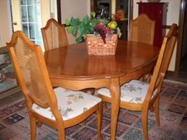 WALNUT DINING TABLE AND CANE BACK CHAIRS