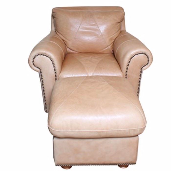 Leather Club Chair with Ottoman: A leather club chair with ottoman. The chair features a cushioned back with rolled arms, cushioned seat and apron front on bun feet. The chair is upholstered in a nude tone leather and includes patchwork piecing and nailhead trim. Also included is a coordinating ottoman with the same patchwork pieced leather cushion top, apron sides, nailhead trim and bun feet.