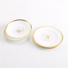 Vintage Minton "Gold Rose" Bone China Tableware: A selection of vintage Minton bone china tableware including two saucers and two bread plates. The pieces feature the Gold Rose pattern with a central gilded rose bloom and a swirling ridged rim with a gilt border to the subtle scalloped edges. The pieces were made in England between 1939-1970 and are marked “Minton H 4680” to the underside.