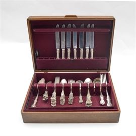 Reed & Barton "Marlborough" Sterling Silver Flatware and Serving Utensils: A sterling silver flatware set in the Marlborough pattern by Reed & Barton Silversmiths. The Marlborough pattern was first introduced in 1906, and features a plumed tip, scroll edge, and a glossy finish. The fifty-one piece set including eight dinner forks, eight salad forks, thirteen teaspoons, two round bowl cream soup spoons, eight flat handle butter spreader knives, one solid gravy ladle, and four tablespoon serving spoons, all marked “Pat. Jan. 2.1906,” embossed with the Eagle/R/Lion marks (mark style ca. 1889 – 1946), and “Sterling” to the backs. Also included are seven New French hollow dinner knives with sterling silver handles and mirrorstele stainless steel blades. The set is presented in a wooden flatware chest with burgundy felt-like interior lining. The total approximate weight, excluding dinner knives with stainless blades, is 52.680 ozt.