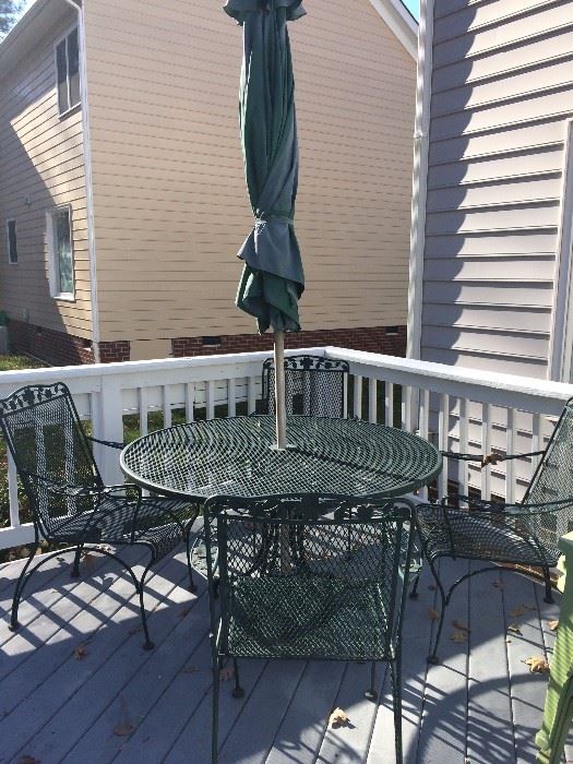 Green wrought iron patio set, four chairs and umbrella. 