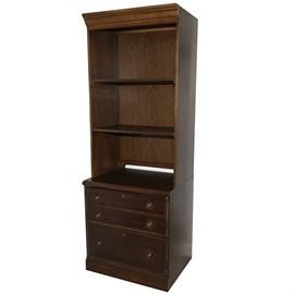 Hutch Bookcase by Stanley Furniture: A hutch bookcase by Stanley Furniture. The mahogany stained bookcase has three drawers to the bottom with keyhole accents to two of the drawers. There are two circular pulls on all three drawers and the top drawer is marked “Stanley Furniture” on the left side. The top of the book shelve features a hutch with two shelves.