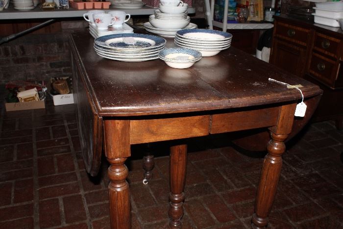 Walnut drop-leaf Victorian table with porcelain casters and 4 walnut leaves and center support leg 