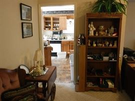 Assorted bric-a-brac and office supplies on an nice wood shelving unit. There is a home made hole in the top section back enough to slide a plug thru.