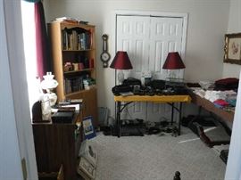 Some electronics, a few books and cds with a smattering of linens grace this middle bedroom.