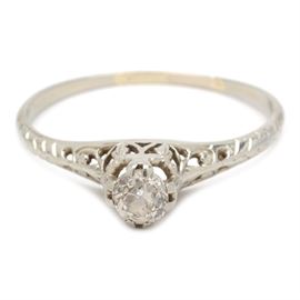 Vintage 18K White Gold Diamond Solitaire Engagement Ring: A vintage 18K white gold diamond engagement ring. The ring features a European cut diamond center stone in a pierced filigree setting.
