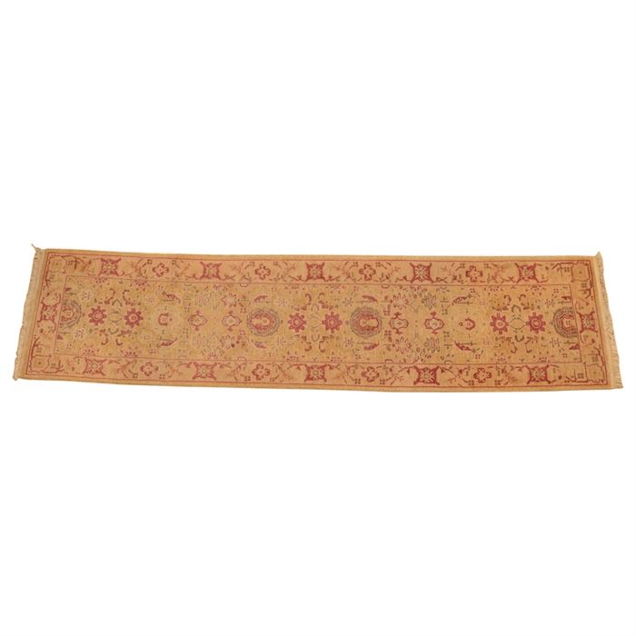 Hand-Knotted Pakistani Carpet Runner: A hand-knotted Pakistani carpet runner. This rug features a maroon and brown palette of palmettes and serrated leaf forms on a tan background. It has a matching primary border, with double overcast selvedge and dense, natural cotton warp fringe to each end. There are no evident tags or markings.