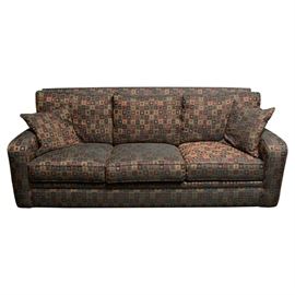 Precedent-Sherrill Furniture Sofa: A Precedent-Sherrill Furniture sofa. This sofa is a three seater.The upholstery features a maroon, beige, green and navy geometric pattern comprising of polyester fibers. There are three removable seat cushions and five pillows. There are two armrests. The tag reads “Made by Precedent A Division of Sherrill Furniture” and “This Furniture Protected with Guardsman Furniture Protection”.
