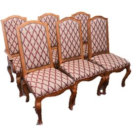 Six Vintage Oak Dining Chairs by Drexel Heritage: A set of six oak dining chairs by Drexel Heritage. These chairs feature rectangular backs with a domed crest and are upholstered with lattice patterned fabric on the backrest and seat cushion in a palette of scarlet, copper, gray and tan and studded with brass nail heads. Each sits on four squared cabriole legs, and two have armrests. This item coordinates with 17COL214-064.