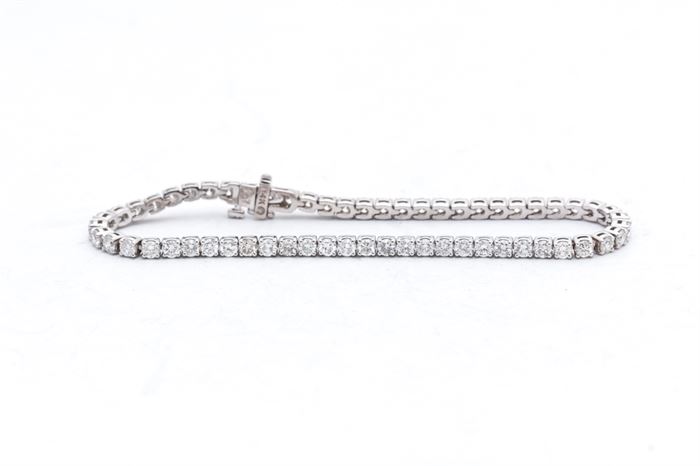 14K White Gold 5.07 CTW Diamond Bracelet: A 14K white gold tennis bracelet comprised of round basket prong set diamonds.