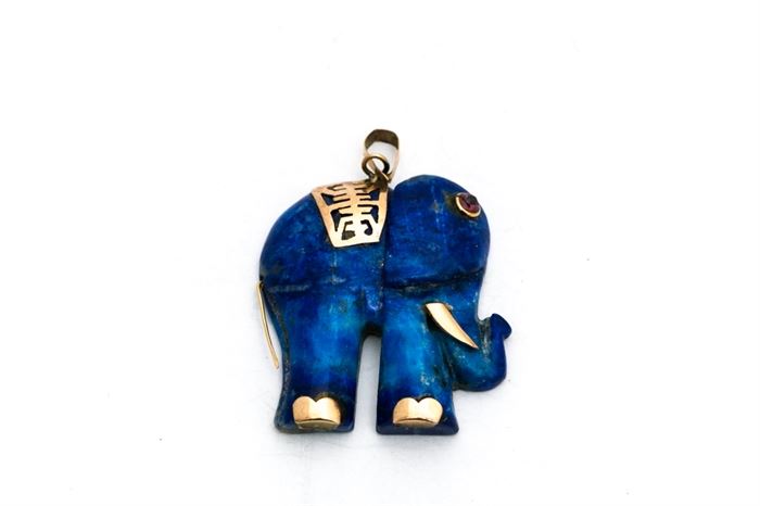 14K Yellow Gold Accented Lapis Lazuli Elephant Pendant: A carved lapis lazuli elephant pendant with 14K yellow gold accented back, tusks, feet, and tail as well as a faceted ruby eye.