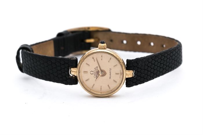 Omega Tiffany & Co. Wristwatch: An Omega Tiffany & Co. wristwatch with small round gold tone case and textured black leather band.