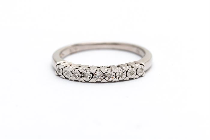 Sterling Silver Diamond Band: A sterling silver band with illusion set round cut diamonds held by heart shaped prongs to the top quarter of the shank.